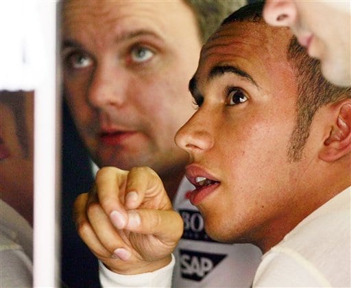 Hamilton watches a monitor with mechanics at the team's garage during the practice session. Hamilton awaits verdict