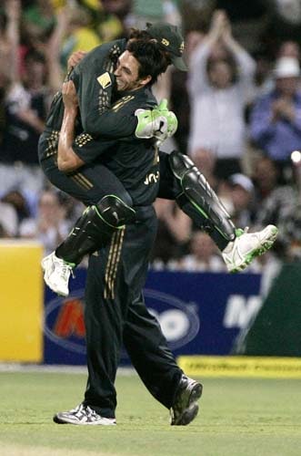 Adam Gilchrist, left, jumps into the arms of teammate Mitchell Johnson after they combined to take the wicket of Harbhajan Singh for 4 runs in their one-day international cricket match at the Adelaide Oval on Sunday, February17, 2008. Australia made 203 in their innings. 7th Match: India vs Australia