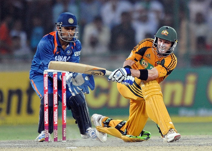 Australia's Michael Hussey plays a shot as India's Mahendra Singh Dhoni looks on during the 3rd ODI match in New Delhi on Saturday. (AFP Photo) 3rd ODI: India vs Australia