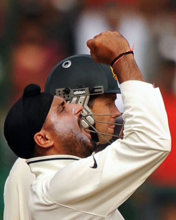Harbhajan Singh celebrates the wicket of Australia's Marcus North as Ricky Ponting reacts on Day 4 of the second Test in Bangalore. (AFP Photo) IND vs AUS: 2nd Test, Day 4