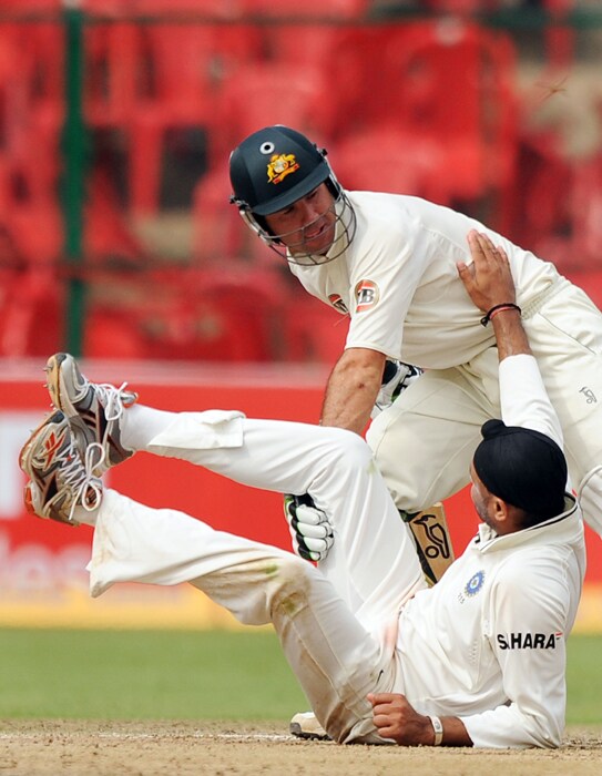 Ricky Ponting helps Harbhajan Singh to stand after he fell on the ground after colliding with Ponting while fielding the ball during the fourth day of the second Test between India and Australia at M.Chinnaswamy Stadium in Bangalore. (AFP Photo) IND vs AUS: 2nd Test, Day 4
