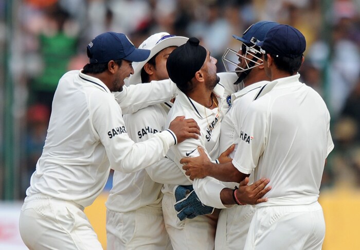 Harbhajan Singh celebrates with teammates the wicket of Michael Clarke during the fourth day of the second Test between India and Australia at M. Chinnaswamy Stadium in Bangalore. (AFP Photo) IND vs AUS: 2nd Test, Day 4