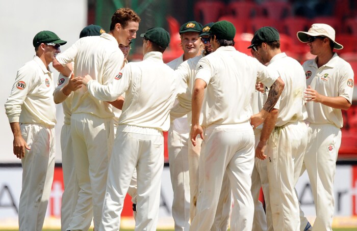 Australian cricketers congratulate Peter George for taking the wicket of Indian cricketer Sachin Tendulkar during the fourth day of the second Test between India and Australia at M.Chinnaswamy Stadium in Bangalore. (AFP Photo) IND vs AUS: 2nd Test, Day 4