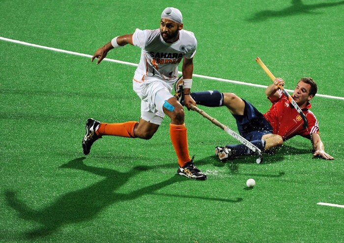 Indian hockey player Sandeep Singh (L) vies for the ball with English hockey player Alastair Brogdon (R) during their World Cup 2010 match at the Major Dhyan Chand Stadium in New Delhi. (AFP Photo) Unbeaten England enter semis