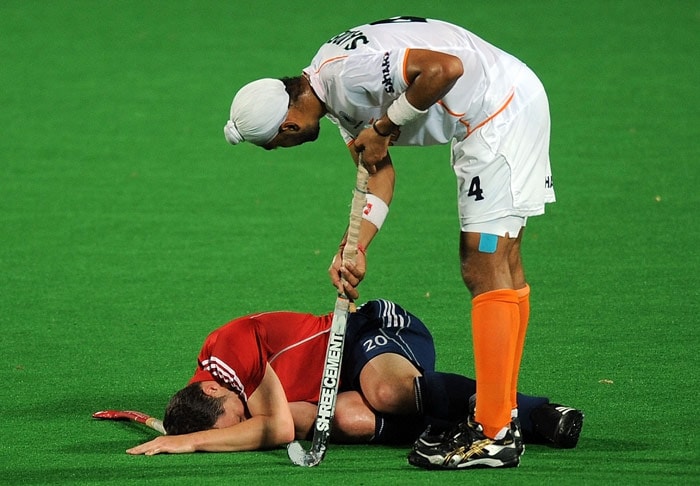 Indian hockey player Sandeep Singh (R) checks on injured English hockey player James Tindall (L) during their World Cup 2010 match at the Major Dhyan Chand Stadium in New Delhi. (AFP Photo) Unbeaten England enter semis