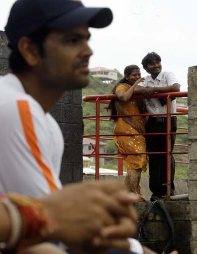 A couple of cricket fans and player RP Singh, foreground, watch the training session at Beausejour ground in Gros-Islet. (AP Photo) India prepare for 3rd ODI