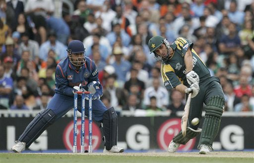 Misbah-ul-Haq hits out as Mahendra Singh Dhoni looks on in their warm up match for the Twenty20 World Championship at the Oval in London. (AP Photo) Ind vs Pak warm-up match