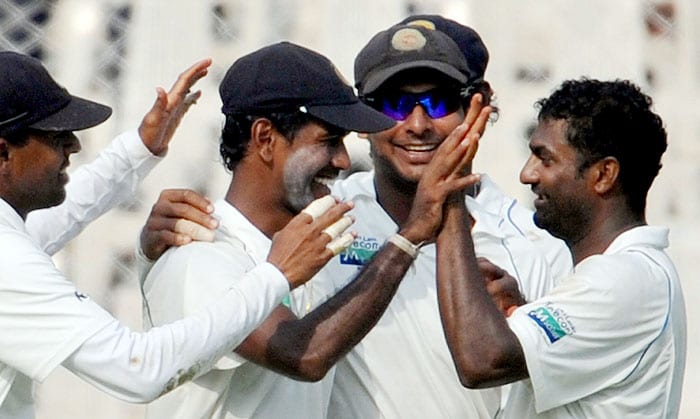Sri Lanka's Muttiah Muralitharan celebrates with teammate Nuwan Kulasekara and captain Kumar Sangakkara after the dismissal of an unseen Indian batsman during the third day of the third Test match in Mumbai on Friday. At the tea interval India were 629 runs for the loss of seven wickets in their first innings. (AFP Photo) India vs SL: 3rd Test, Day 3
