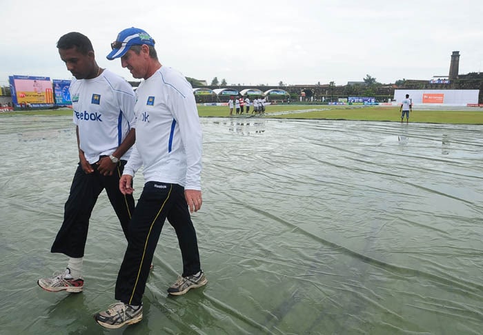 Thilan Samaraweera and coach Trevor Bayliss inspect the pitch following rain that delayed the start of the second day of the first Test match between Sri Lanka and India in Galle. (AFP Photo) India vs SL: 1st Test, Day 2