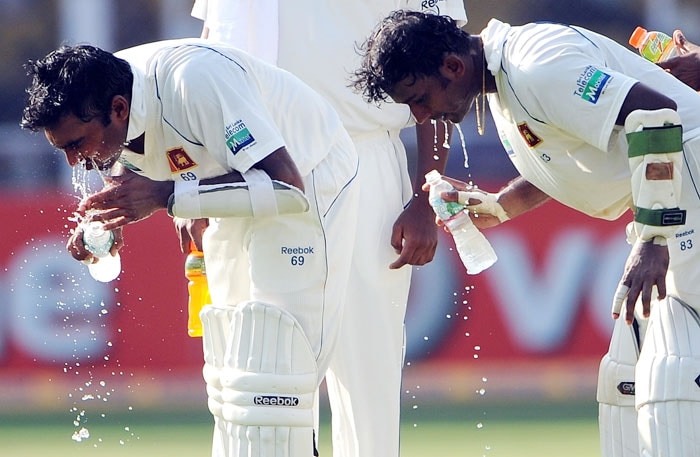 Mahela Jayawardene and Prasanna Jayawardene pour water on their face during the third day of the first Test match between India and Sri Lanka at the Motera stadium in Ahmedabad. (AFP Photo) India vs SL: 1st Test, Day 3