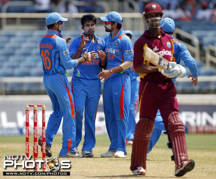 India's Vinay Kumar is congratulated by teammates Shikhar Dhawan and Virat Kohli after taking the wicket of West Indies' Lendl Simmons during their fifth One-Day International in Kingston, Jamaica. (AP Photo) 5th ODI: India vs West Indies