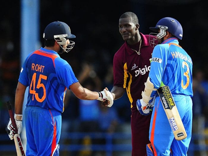 West Indies captain Darren Sammy shakes hands with Indian batsmen Rohit Sharma and Harbhajan Singh after the latter hit India's victory shot during the first ODI between West Indies and India at the Queen's Park Oval in Port of Spain. India scored 217/6 (44.5 overs) in reply to West Indies 214/9 (50 overs). India won by 4 wickets (with 31 balls remaining). (AFP Photo) 1st ODI: India vs West Indies