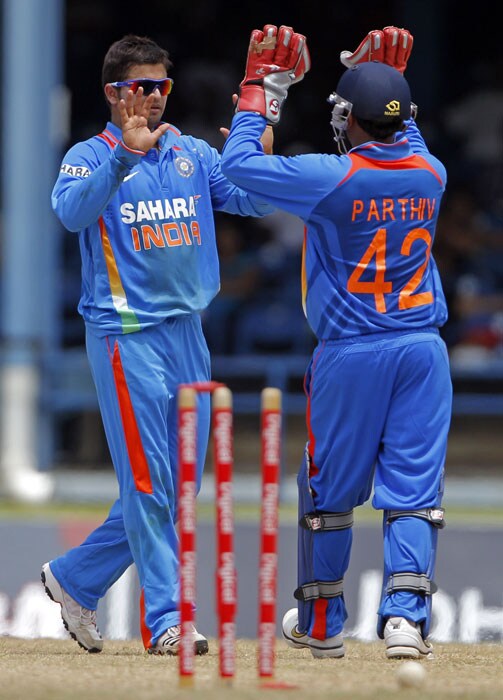 Suresh Raina high fives with the Parthiv Patel after bowling out Marlon Samuels for 55 runs during their first One-Day International in Port of Spain, Trinidad. (AP Photo) 1st ODI: India vs West Indies