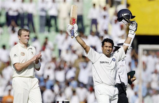 Sachin Tendulkar acknowledges the crowd after becoming the leading run-scorer in Test cricket as Peter Siddle applauds on the first day of the second Test in Mohali. Tendulkar surpassed Brian Lara's record mark of 11,953 runs. India vs Australia: 2nd Test, Day 1