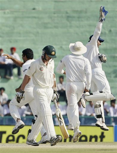 Brett Lee walks back after losing his wicket as Zaheer Khan and Mahendra Singh Dhoni celebrate during the final day of the second Test between India and Australia in Mohali. India vs Australia: 2nd Test, Day 5