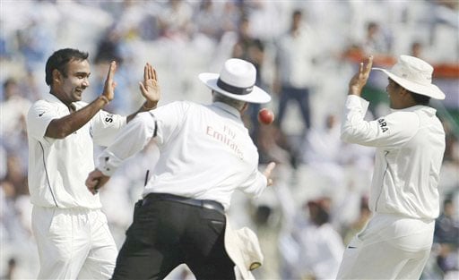 Amit Mishra is congratulated by Sachin Tendulkar as umpire Rudi Koertzen takes the ball after Mishra took the wicket of Mitchell Johnson on the final day of the second Test between India and Australia in Mohali. India vs Australia: 2nd Test, Day 5