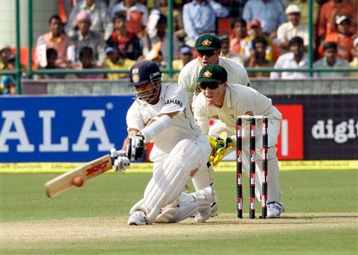 Sachin Tendulkar, left, hits a shot as Australian wicketkeeper Brad Haddin and Matthew Hayden, back, look on during the first day of their third cricket Test match in New Delhi on Wednesday, October, 2008. India vs Australia: 3rd Test, Day 1