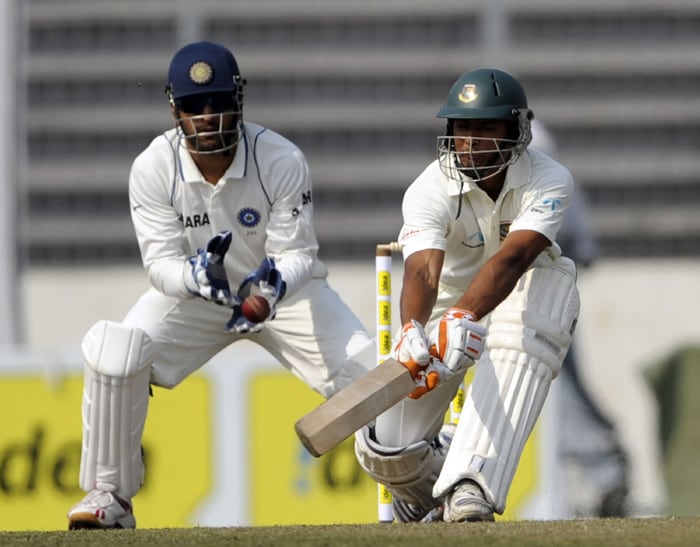 Bangladeshi cricketer Mahmudullah Riyad plays a shot enroute to his 96* as Indian cricket team captain Mahendra Singh Dhoni looks on during the first day of the second Test. (AFP Photo) Ind vs B'desh: 2nd Test, Day 1