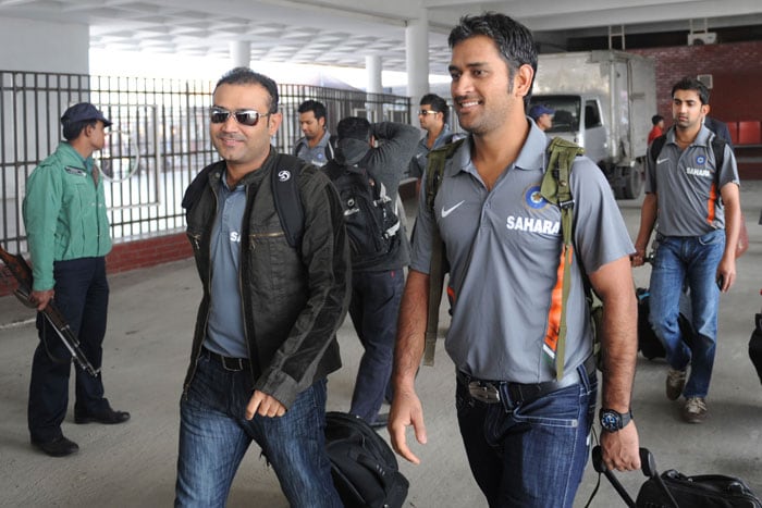 Virender Sehwag and Mahendra Singh Dhoni walk after arriving at the Zia International Airport in Dhaka. (AFP Photo) Team India arrive in B'desh