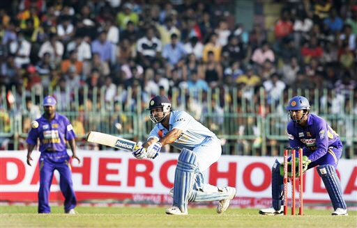 Mahendra Singh Dhoni plays a shot as Sri Lankan wicketkeeper Kumar Sangakkara and Muttiah Muralitharan look on during the second One-Day International between India and Sri Lanka in Colombo. 2nd ODI: India vs Sri Lanka