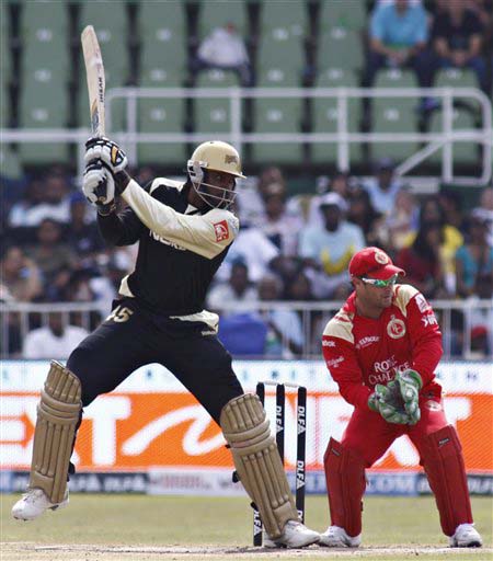 Kolkata Knight Riders' Chris Gayle plays a shot as Royal Challengers Bangalore's wicketkeeper Mark Boucher looks on during their IPL match in Durban on Wednesday. (AP Photo) Match 19: BLR vs KOL