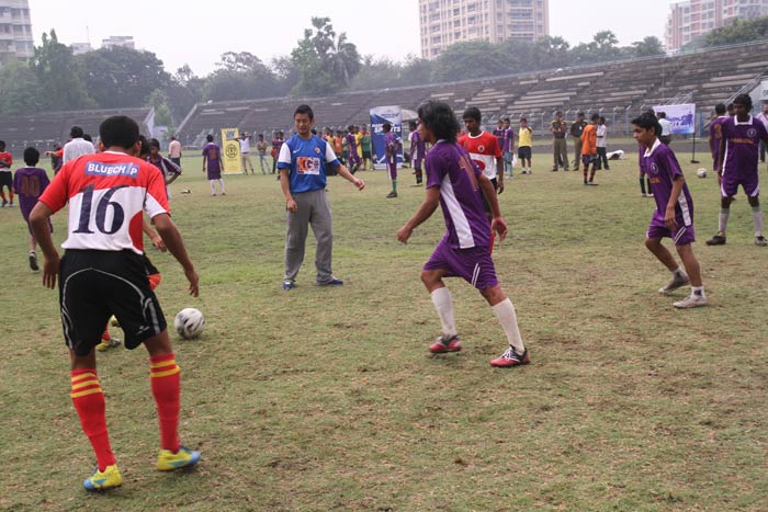 Participants play football with Coach Baichung.
