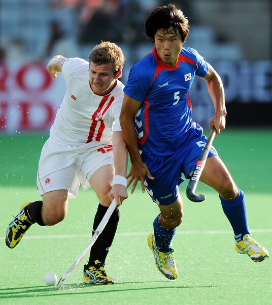 South Korean hockey player Nam Hyun Woo (R) vies for the ball with Canadian hockey player Mark Pearso (L) during their World Cup 2010 match at the Major Dhyan Chand Stadium in New Delhi. (AFP Photo) South Korea beat Canada