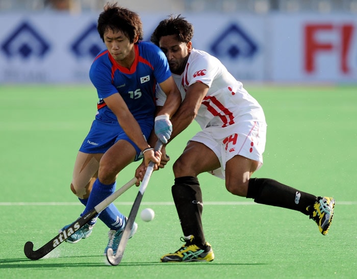 South Korean hockey player Kang Moon Kyu (L) vies for the ball with Canadian hockey player Gabbar Singh (R) during their World Cup 2010 match at the Major Dhyan Chand Stadium in New Delhi. (AFP Photo) South Korea beat Canada