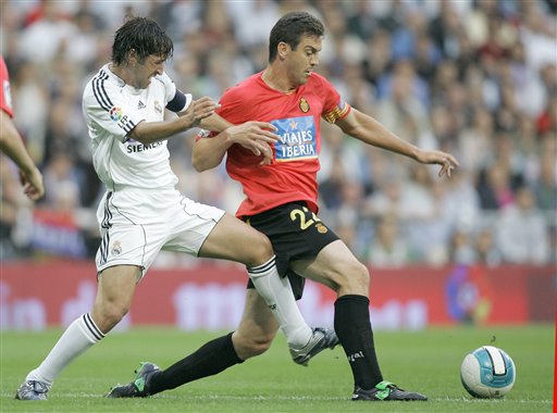 Real Madrid player Raul Gonzalez, left, duels for the ball with Mallorca player Sergio Ballesteros, right, during their Spanish League soccer match against Mallorca in Madrid. Real Madrid win La Liga