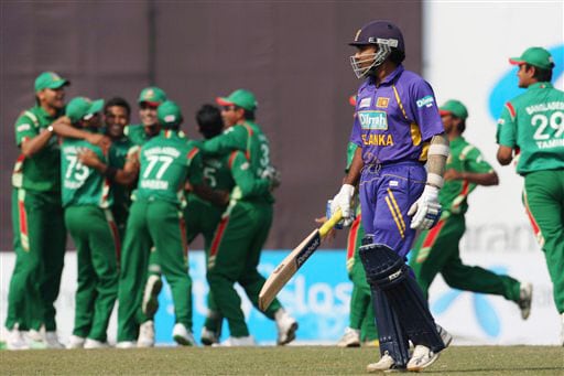 Mahela Jayawardene walks back to the pavilion as Bangladeshi cricketers celebrate his dismissal on the final match of a triangular limited-overs international series between Bangladesh and Sri Lanka in Dhaka. Sri Lanka win tri-series final