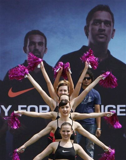 Cheerleaders perform before an event to showcase the new apparel for the Indian one-day international team in Mumbai on Wednesday. In the backdrop are photographs of Mahendra Singh Dhoni and Zaheer Khan. (AP Photo) New jersey for Team India