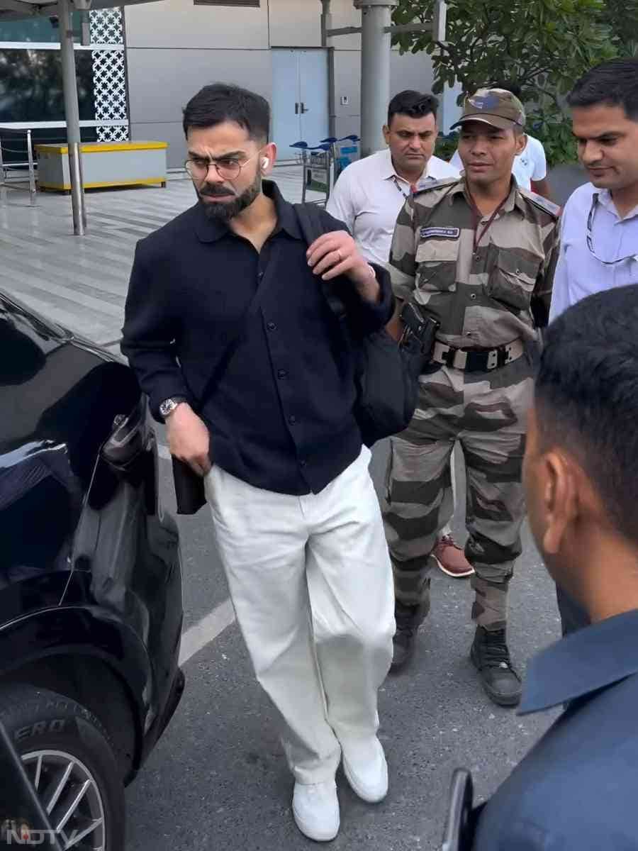एयरपोर्ट से बाहर आते समय कोहली काले रंग का शर्ट पहने हुए नजर आए हैं
