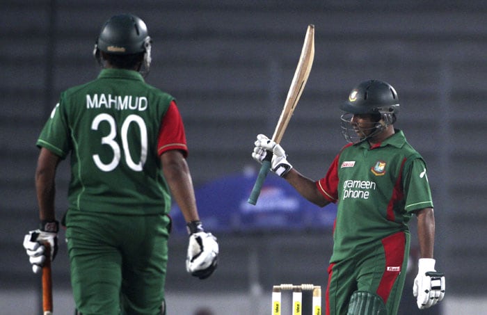 Bangladesh's Mohammad Ashraful raises his bat to celebrate scoring a half-century as teammate Mahmudullah Riyad walks to congratulate him during their first One-Day International of the tri-series against Sri Lanka in Dhaka. (AP Photo) 1st ODI: SL vs B'desh