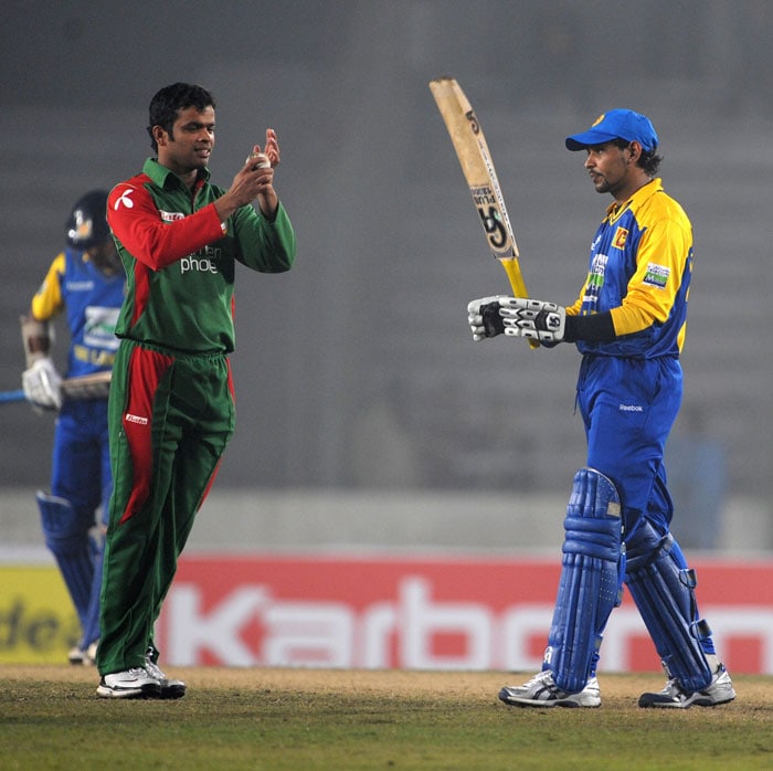 Sri Lanka's Tillakaratne Dilshan acknowledges the crowd as Bangladesh's Abdur Razzak congratulates him after scoring a half-century during their first One-Day International of the tri-series in Dhaka. (AFP Photo) 1st ODI: SL vs B'desh