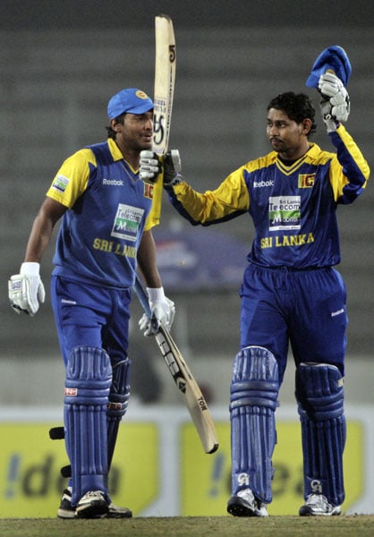 Sri Lanka's Kumar Sangakkara looks on as teammate Tilakaratne Dilshan raises his bat to celebrate scoring a century against Bangladesh during their first One-Day International of the tri-series in Dhaka. (AP Photo) 1st ODI: SL vs B'desh