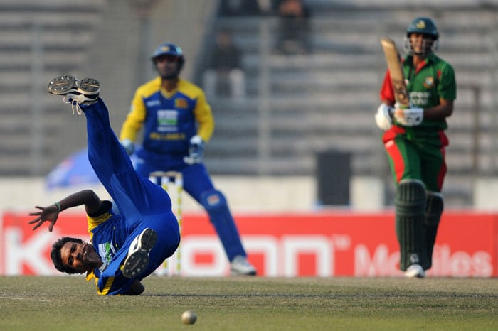 Malinga Bandara tries to field a ball as Kumar Sangakkara and Bangladeshi cricket team captain Shakib Al Hasan look on during the fourth ODI of the tri-series in Dhaka. (AFP Photo) 4th ODI: SL vs B'desh