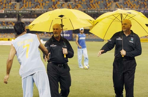 Indian cricket captain MS Dhoni, left, shakes the hands of umpires Rudi Koertzen and Steve Davis, right, after their One-Day cricket international against Sri Lanka was abandoned due to rain in Brisbane on Tuesday, February 5, 2008. 2nd Match: India-Lanka