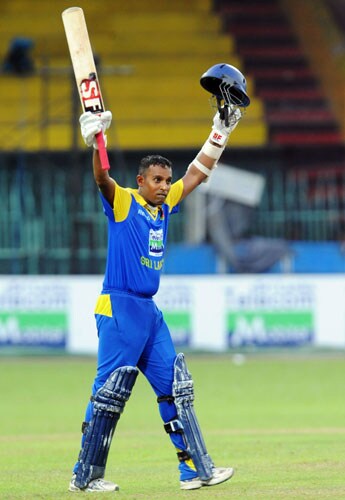 Sri Lanka's Thilan Samaraweera raises his bat and helmet in celebration after scoring a century (100 runs) during the first ODI of the Tri-Nation Championship trophy in Colombo. (AFP Photo) Tri-series: SL vs NZ