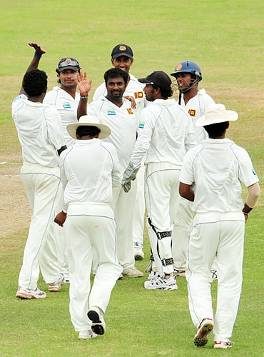 Sri Lankan cricketer Muttiah Muralitharan is congratulated by teammates after dismissing unseen New Zealand batsman Jacob Oram during the third day of the first Test match at The Galle International Cricket Stadium in Galle on Thursday. (AFP Photo) SL vs NZ: 1st Test, Day 3