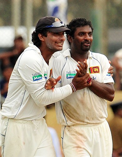 Sri Lankan cricketer Muttiah Muralitharan is congratulated by captain Kumar Sangakkara after dismissing unseen New Zealand batsman Tim McIntosh during the third day of the first Test match at The Galle International Cricket Stadium in Galle on Thursday. (AFP Photo) SL vs NZ: 1st Test, Day 3