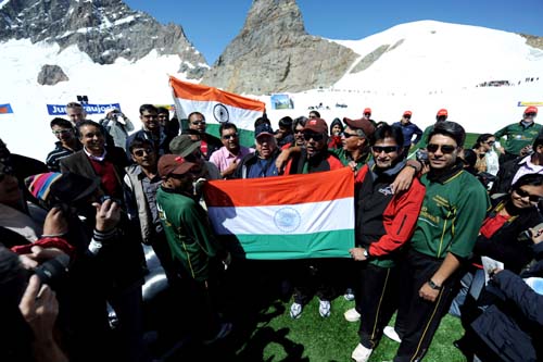 Indian former cricketers along with Indian tourists sing the national anthem before the start of a cricket match on snow in Bernese Alps in Switzerland on August 15, 2009. Indian sports tourism company Beyond Boundaries organised for the first time a cricket on Snow match. This on the Indian Independance day where a 6-a-side five over match was held at 11,333ft at Jungfrau in the Bernese Alps in Switzerland. Kapil Dev led the Indian team that won by four runs against the All Stars team led by former West Indian cricketer Allvin Kallicharran. (AFP Photo) Cricket touches 'cool' heights