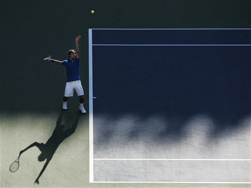 Roger Federer of Switzerland serves to John Isner of the United States at the US Open tennis tournament in New York on Saturday. US Open - Day 6