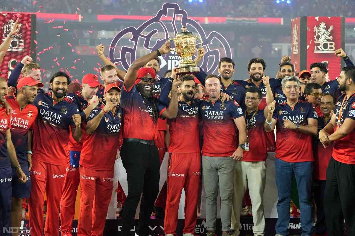 बेंगलुरु की जीत के बाद क्रिस गेल और डिविलियर्स विजेत टीम के साथ ट्रॉफी उठाते हुए नजर आए. (फोटो क्रेडिट:आईएएनएस)
