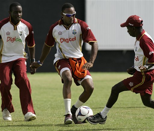 West Indies' all-rounder Dwayne Bravo, center, drives with a soccer ball guarded by assistant coach David Williams, right, and teammate Xavier Marshall, while warming up for a training session at the Antigua Recreation Ground in St. John's on Wednesday, May 28, 2008. The second cricket Test match between West Indies and Australia begins on Friday. Australia-West Indies, practice session