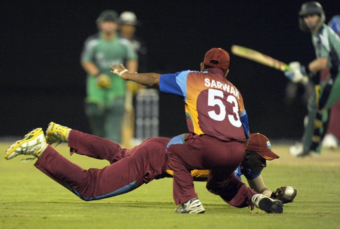 Ramnaresh Sarwan of West Indies look on as teammate Darren Sammy dives to take a catch of William Porterfield of Ireland during their ICC World Twenty20 2010 match at the Providence Stadium in Guyana. (AFP Photo) T20 WC: WI vs IRE