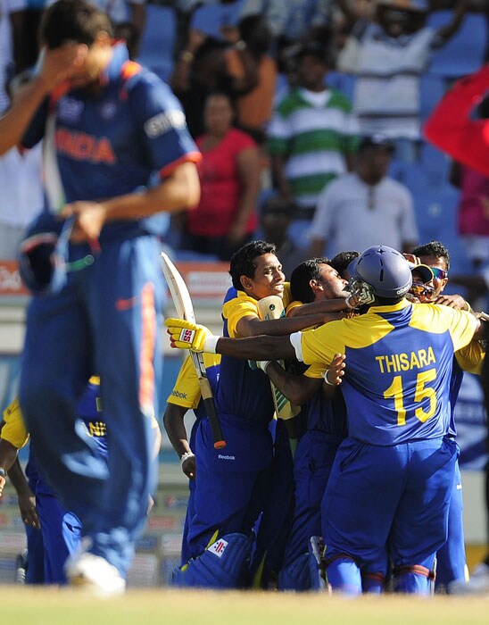 Sri Lankan players celebrate their victory as Indian bowler Ashish Nehra (L) reacts during the ICC World Twenty20 Super Eight match between India and Sri Lanka at the Beausejour Cricket Ground on Tuesday in St Lucia. Sri Lanka won by 5 wickets to eliminate India. (AFP Photo) WT20: Ind vs SL