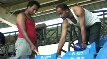 Football players resort to cleaning cricket stadium
