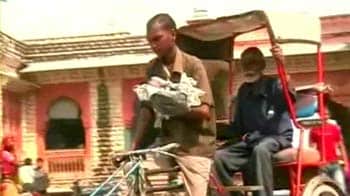 This rickshaw puller has a child strapped to his chest