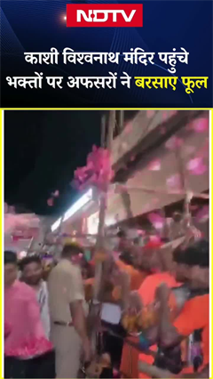 काशी विश्वनाथ मंदिर में पूजा के लिए कतार में खड़े श्रद्धालुओं पर जिला प्रशासन की ओर से बरसाए गए फूल