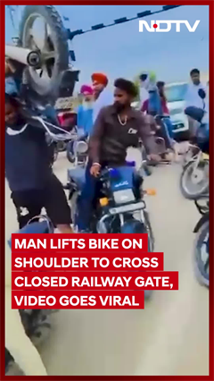 Man Lifts The Bike On His Shoulder to Cross Closed Railway Gate, Video Goes Viral Man Lifts The Bike On His Shoulder to Cross Closed Railway Gate, Video Goes Viral